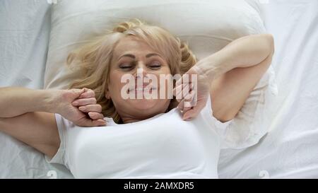 Optimistische Frau mittleren Alters, die früh am Morgen aufwacht, Vitalität und Energie Stockfoto