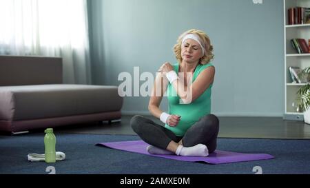Sportlerin mittleren Alters spürt Schulterschmerzen nach dem Workout, Gelenkentzündung Stockfoto