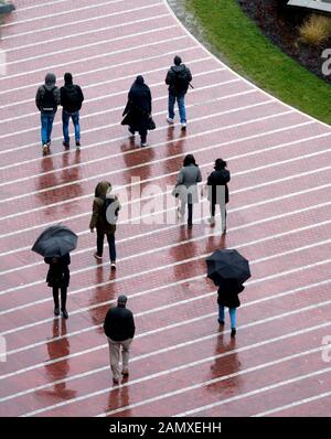 Luftaufnahme von Menschen, die bei nassem Wetter im Winter spazieren gehen, Centenary Square, Birmingham, Großbritannien Stockfoto