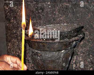 Der Mönch beleuchtet eine traditionelle Öllampe im Kloster Kebran Gabriel, Kebran Gabriel Island, Lake Tana. Äthiopien. Stockfoto