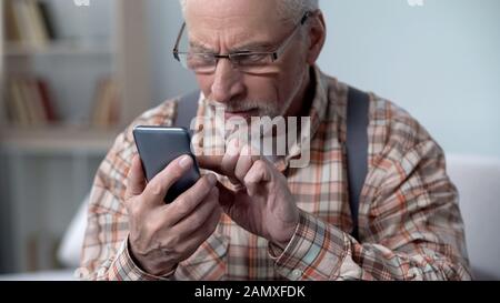 Alter Mann vorsichtig mit Smartphone, Lern-Apps und neuen Technologien, Nahaufnahme Stockfoto