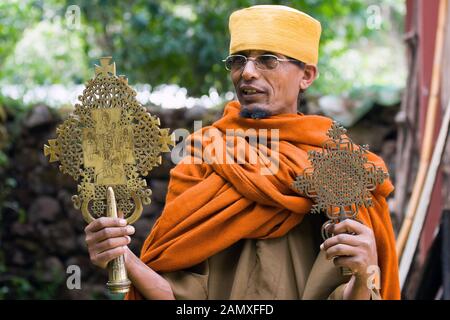 Priester in Bahir dar, der ein important-Kruzifix vor dem Kloster Kebran Gabriel, Kebran Gabriel Island, Lake Tana zeigt. Äthiopien. Stockfoto