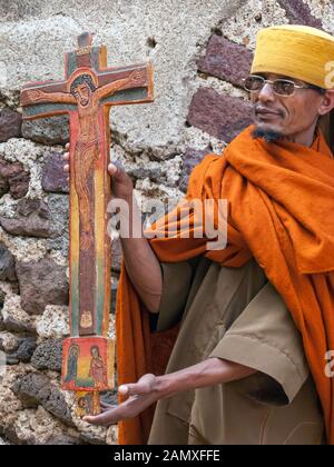 Priester in Bahir dar, der ein important-Kruzifix vor dem Kloster Kebran Gabriel, Kebran Gabriel Island, Lake Tana zeigt. Äthiopien. Stockfoto