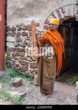 Priester in Bahir dar, der ein important-Kruzifix vor dem Kloster Kebran Gabriel, Kebran Gabriel Island, Lake Tana zeigt. Äthiopien. Stockfoto