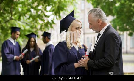 Aufgeregter Vater gratulierte der Diplomatentochter im Park in der Nähe der Akademie zum Glück Stockfoto