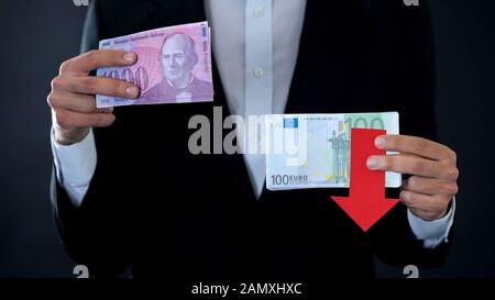 Man hält Banknoten, Euro fällt im Verhältnis zum schweizer Franken, Finanzprognose Stockfoto