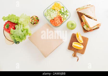 Sandwich auf Schneidebrett auf dem Tisch in der hellen Küche. Mittagessen. Sandwich mit Salat. Gesunde Ernährung Konzept. Stockfoto