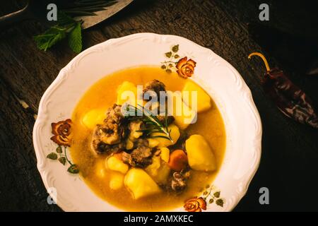 Rindfleisch chunky Eintopf mit Kartoffeln, hausgemachten Stil in eine alte Platte auf einem alten Holztisch. Stockfoto