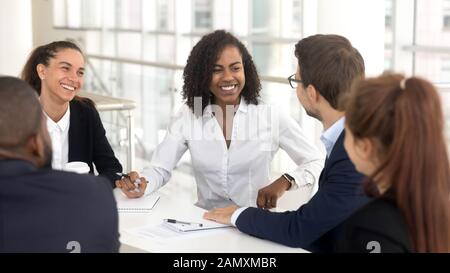 Lächelnde Mitarbeiter diskutieren Ideen-Brainstorming bei Bürotreffen Stockfoto