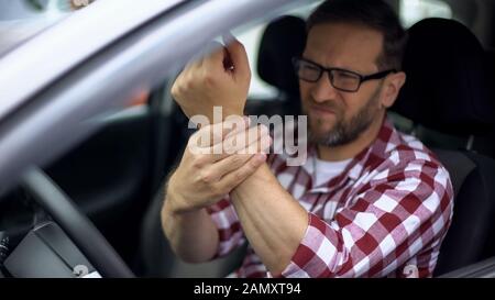 Autofahrer spüren Handgelenkschmerzen, Gelenkentzündung, Arthrose, Gesundheit Stockfoto