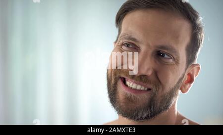 Mann mittleren Alters, der die Zähne vor dem Spiegel, Zahnerkrankung, Zahnfleischinfektion überprüft Stockfoto