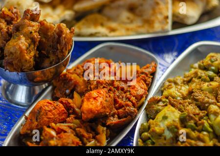 Huhn Jalfrezi und Chicken curry mit verschiedenen Reis und Zwiebeln Bhajis und Samosas, traditionelle indische Gericht Stockfoto