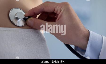 Professioneller Therapeut, der den Patienten mit Stethoskop hört, Gesundheitsdiagnostik Stockfoto