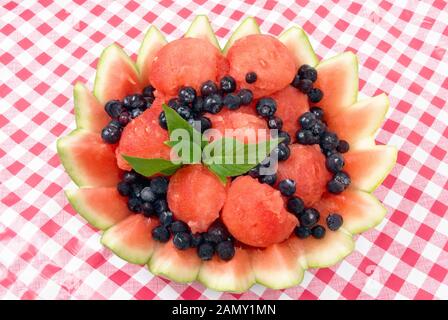 Frische hausgemachte Wassermelone und bluberry Fruchtsalat mit Stevia-Blättern als Pfennig in einer dekorativen Rindenschale. Stockfoto