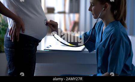 Arzt hört Herzschlag des Kindes im Bauch der zukünftigen Mutter, Schwangerschaft Stockfoto