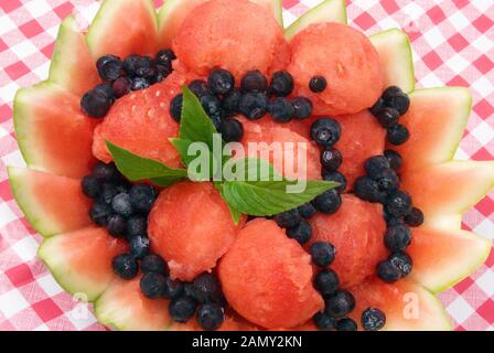 Frische hausgemachte Wassermelone und bluberry Fruchtsalat mit Stevia-Blättern als Pfennig in einer dekorativen Rindenschale. Stockfoto