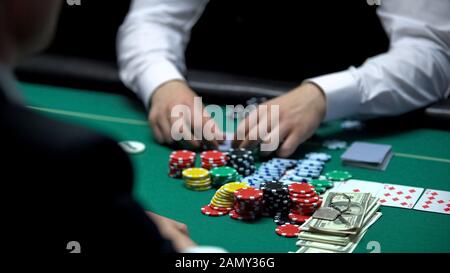 Pokerspiel, Spieler hat eine Kombination aus Gewinnkarten, Wetten auf alle Bargeld- und Hausschlüssel Stockfoto