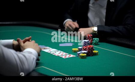 Reicher Geschäftsmann, der große Wetten macht, Poker im illegalen Casino spielt, sucht Stockfoto