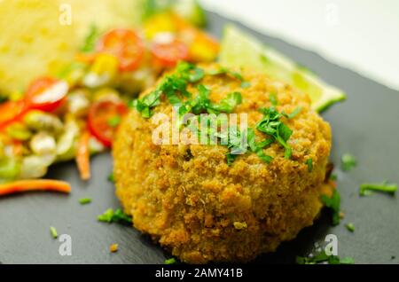 Geräucherten Schellfisch Fischkuchen mit Bratkartoffeln und gemischtem Salat, Fisch und Meeresfrüchte Stockfoto