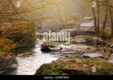 Gebirgsfluss im späten Herbst zwischen riesigen Steinen, malerischer Landschaft, Tourismus Stockfoto