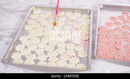 Schritt für Schritt. Verstauen Sie Schokoladenschneeflocken mit glitzerndem Lebensmittelstaub. Stockfoto