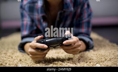 Teenager spielen Videospiele auf der Konsole, gewinnen gegen Kerl Freunde, unterhalten Stockfoto