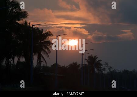 Die untergehende Sonne. Sonnenuntergang Sonnenuntergang. Abendhimmel. Verschwinden der Sonne unter dem Horizont. Schöne atmosphärische Refraktion leuchtet Sonnenlicht strahlen und astr Stockfoto