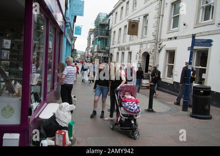 Keswick The Lake District UK Baby in Kinderwagen und Hundestatue Hundeschild Menschen gehen Schiffspoller Pub Bar Bogengeschäft Geschäfte Gerüste Hunde Kinder Touristen Stockfoto