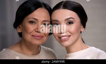 Zwei lächelnde asiatische Frauen, die Kamera betrachten, Mutter und Tochter sehen sich Nahaufnahme gegenüber Stockfoto