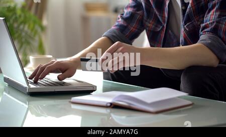 Mann mit Kreditkarte, Eingabe auf Laptop, Zahlung für Dienstprogramme, Online-Shopping Stockfoto