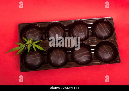 Cookies Schokolade mit Marshmallows und Marihuana. Cannabis Cookies Anzeigen auf rotem Hintergrund. Stockfoto