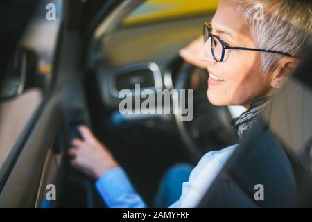 Portrait der Frauenanteil Fahrer lächelnd im Auto. Stockfoto