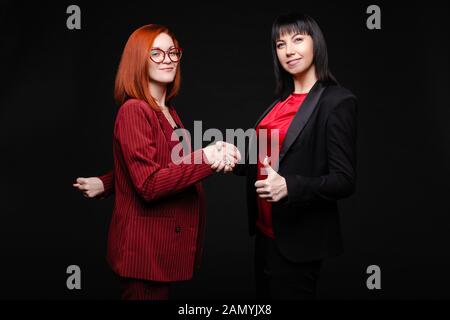 Hübsches Lächeln Geschäftsfrauen zitternde Hände zueinander Stockfoto