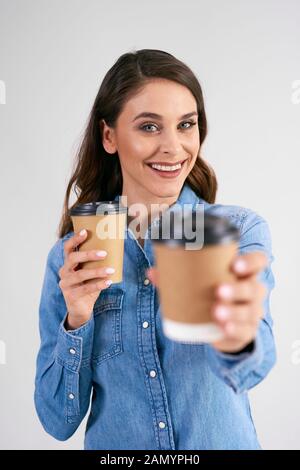 Porträt einer lächelnden Frau mit Einwegbecher Stockfoto