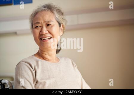 Porträt einer asiatischen alten Frau, die im Rollstuhl im Pflegeheim sitzt, glücklich und lächelnd Stockfoto