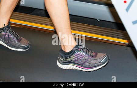 Die Personen, die Füße sind und laufen auf einem Laufband im Inneren. Stockfoto