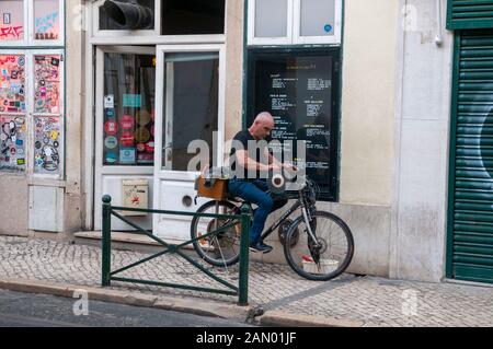 Ein Mann schärft mit Hilfe eines Radrads die Messer. Fotografiert in Lissabon, Portugal Stockfoto