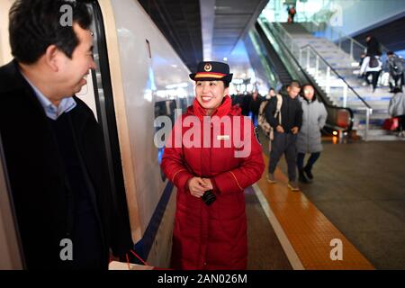 (200115) -- TAIYUAN, 15. Januar 2020 (Xinhua) -- der Zugführer Chen Haiyan verabschiedet sich von den Passagieren am Nordbahnhof Xi'an in Xi'an, nordwestchinesische Provinz Shaanxi, 11. Januar 2020. Während Millionen Chinesen nach Hause gehen, um den Vorabend des Frühlingsfestes zu fangen, werden Chinas Lunar-Neujahr, Zhao Yao und Chen Haiyan, ein Paar, die beide als Schaffner in Zügen arbeiten, den Geburtstag ihrer Tochter wieder verpassen, der am selben Tag des Vorabend fällt. Auch der wichtigste Familientreffen für Chinesen. Es gibt nur drei Mal, dass das Paar den Geburtstag mit seiner Tochter verbringt Stockfoto