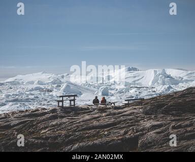 Blick Richtung in Ilulissat Icefjord. Eisberge von Kangia Gletscher in Grönland schwimmen mit blauen Himmel und Wolken. Symbol der globalen Erwärmung. Stockfoto