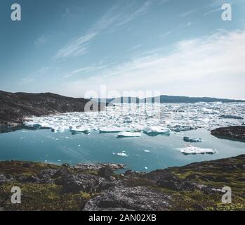 Wunderschöne Landschaft mit schwimmenden Eisbergen in der Gletscherlagune und dem See in Grönland. Ilulissat Icefjord-Gletscher. Eisberg und Eis vom Gletscher in Stockfoto