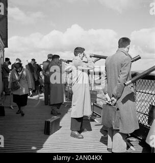 1950, historische, Männer in Mänteln, außerhalb auf einem hölzernen Aussichtsplattform hoch oben auf der berühmten französischen Wahrzeichen, dem Eiffelturm, mit den Teleskopen über die Stadt, Paris, Frankreich zu sehen. Stockfoto