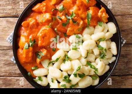 Das klassische ungarische Chicken Paprikash Rezept ist eine bequeme Mahlzeit auf einem Teller auf dem Tisch. Horizontale Draufsicht von oben Stockfoto