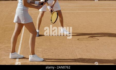 Junge Frau und Mann, die auf dem Tennisplatz spielen, aktiver Lebensstil, Nahsicht Stockfoto