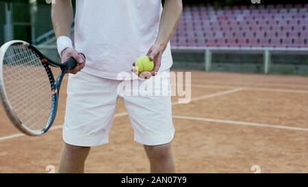 Erfahrener Tennisspieler, der Ball für Gegner, Schlägersport und Hobby serviert Stockfoto