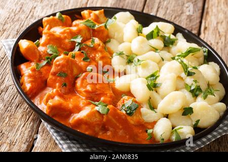 Das klassische ungarische Chicken Paprikash Rezept ist eine bequeme Mahlzeit auf einem Teller auf dem Tisch. Horizontal Stockfoto