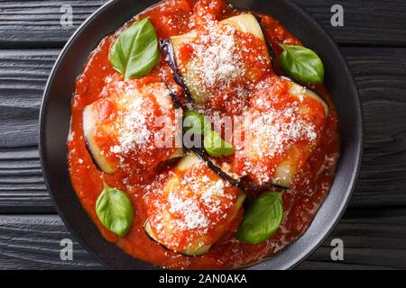 Leckere Auberginwalzen mit Käse gefüllt und in Tomatensauce in einem Teller auf dem Tisch gebacken. Horizontale Draufsicht von oben Stockfoto