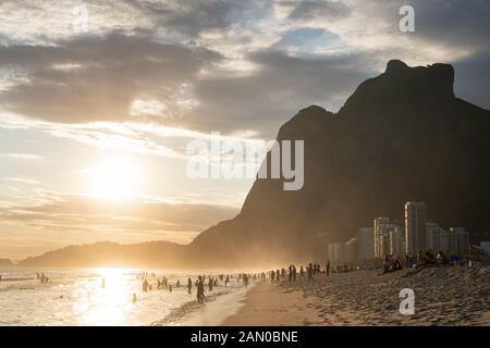 Sonnenuntergang vom Strand Sao Conrado in Rio de Janeiro mit dem am Meer gelegenen Berg Pedra da Gavea aus Granit. Stockfoto