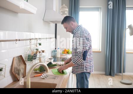 Mann in einem kariertem Hemd Frühstück machen Stockfoto