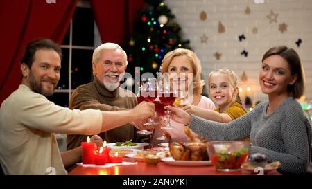 Große, freundliche Familienbrille mit Wein am Weihnachtsabend, Blick in die Kamera Stockfoto