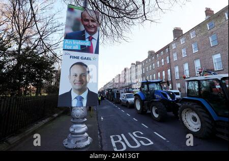 Wahlplakate für den Anführer Der Fine Gael Leo Varadkar (unten) und Anführer der Fianna Fail Micheal Martin werden auf einem Lampenposten am Merrion Square gesehen, da die Traktoren um das Stadtzentrum von Dublin geparkt werden, als Protest der Landwirte über die Preise, die sie für ihre Produkte erhalten, weitergeht. Stockfoto